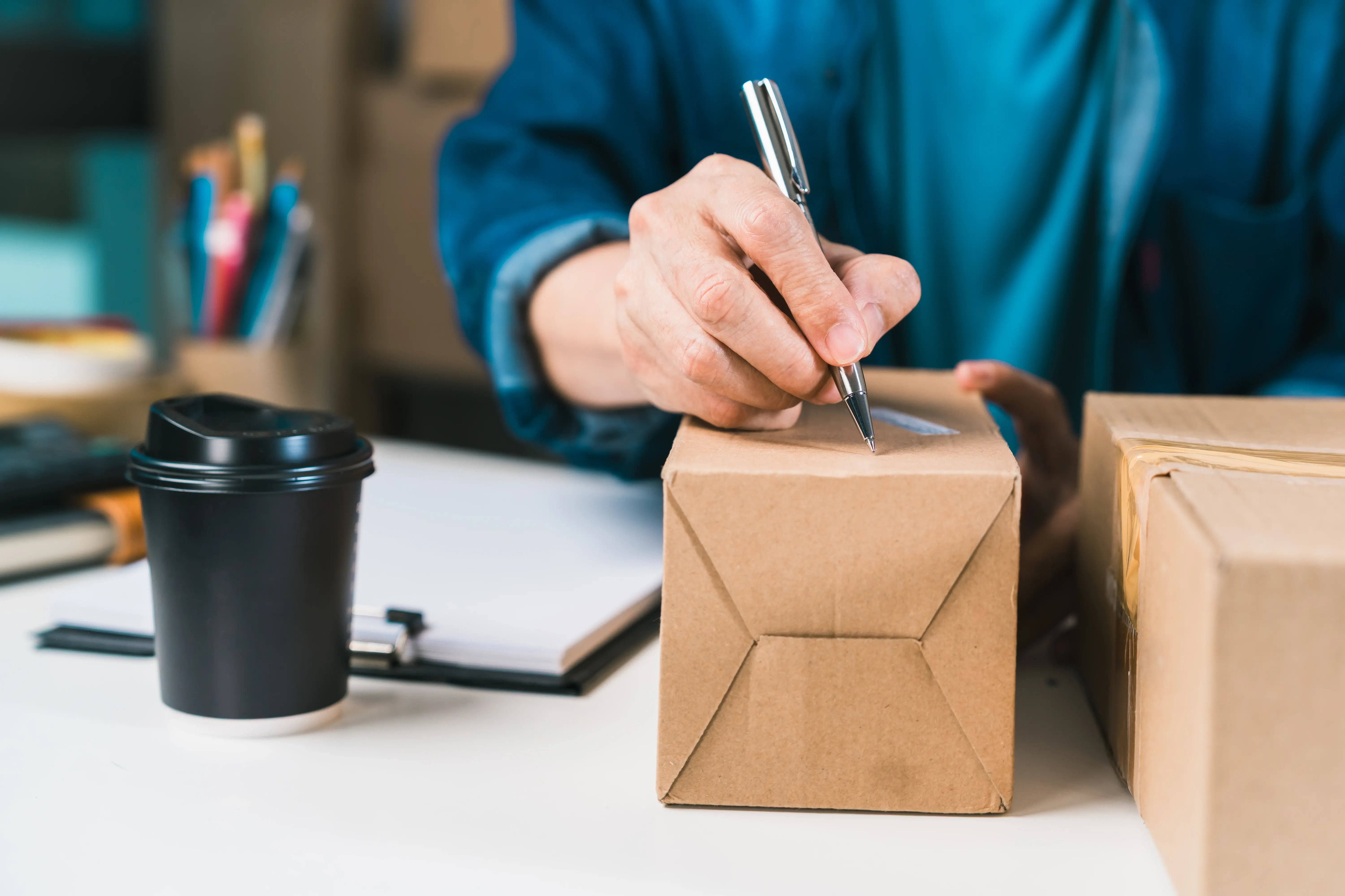 person-writing-delivery-information-on-cardboard-s-2026-07-15-19-48-52-utc