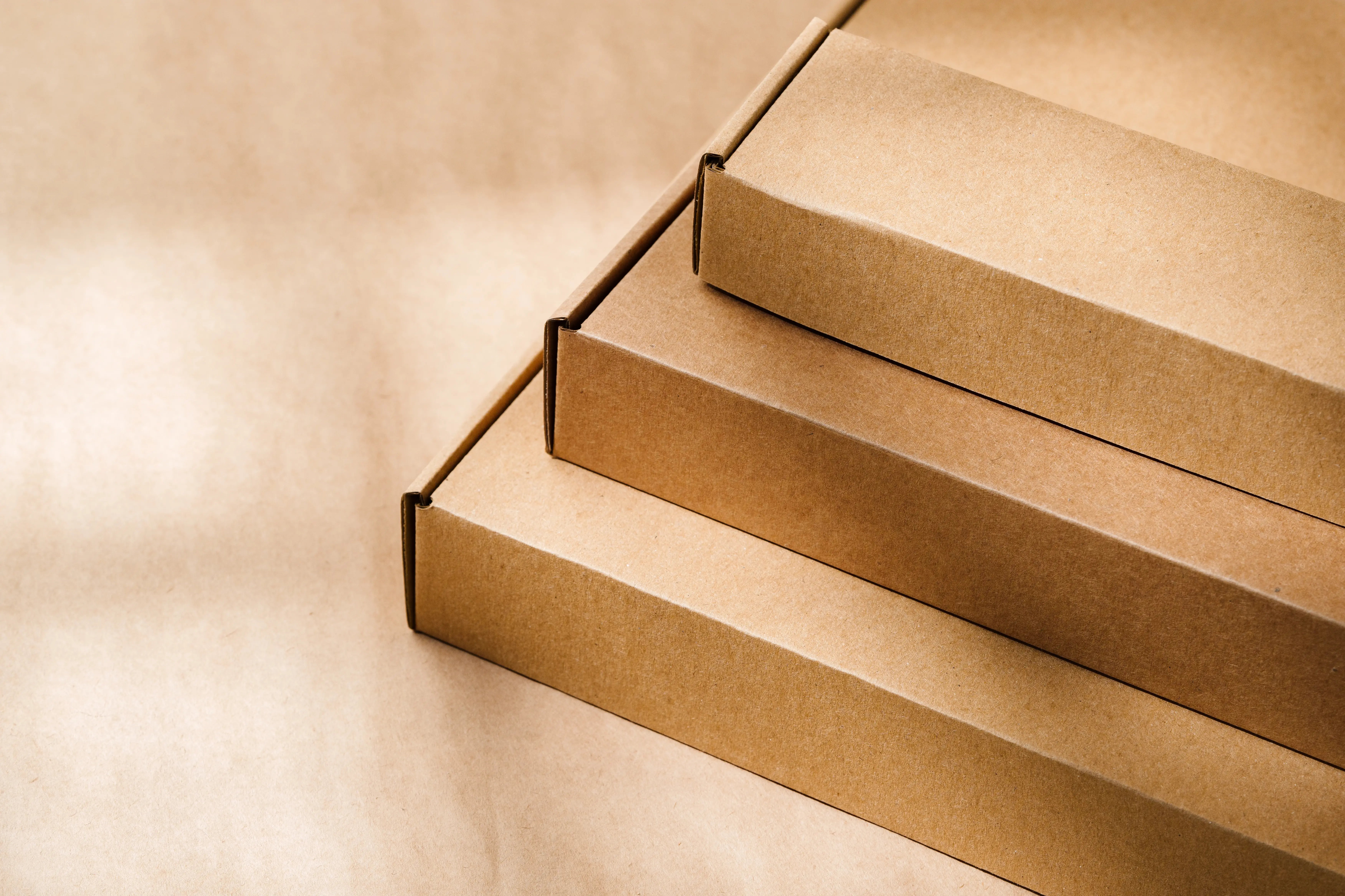 three-brown-cardboard-boxes-stacked-on-brown-paper-2026-01-08-08-07-16-utc